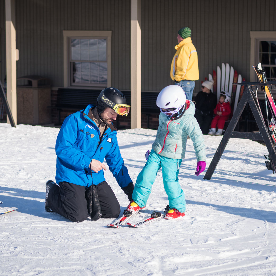 Ski Instructor Helps Little Girl Clip Into Ski at Alpine Valley