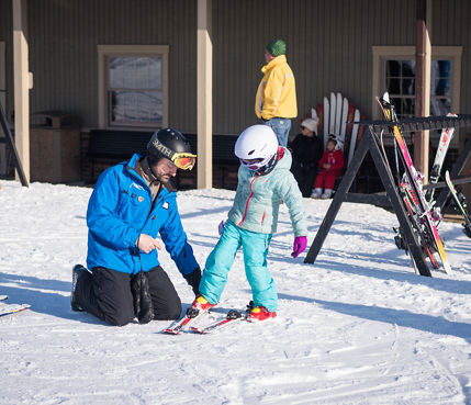 Ski Instructor Helps Little Girl Clip Into Ski at Alpine Valley