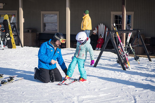 Ski Instructor Helps Little Girl Clip Into Ski at Alpine Valley