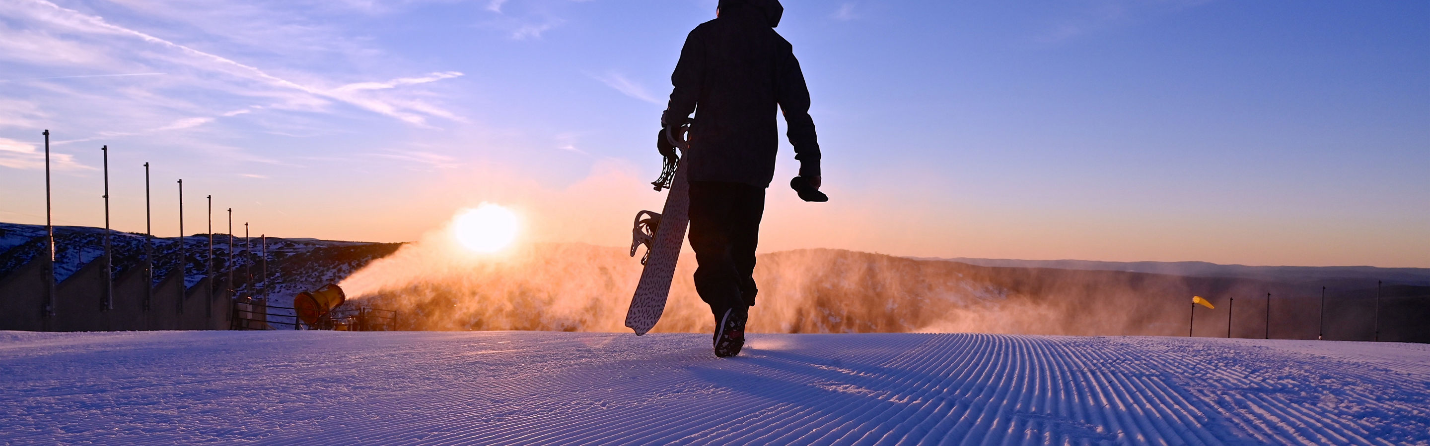 A snowboarder walks on freshly groomed corduroy snow at Heavenly Valley at Hotham