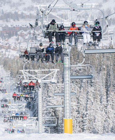 Family skis under the Montezuma lift at Keystone, CO.