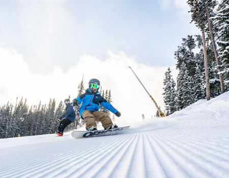 Father and son ride the fresh snow together in Keystone, CO.