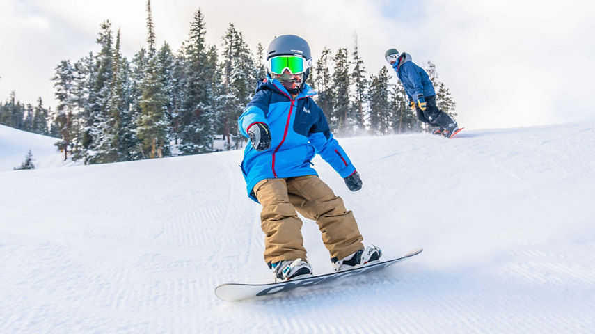 Father and son ride the fresh snow together in Keystone, CO.