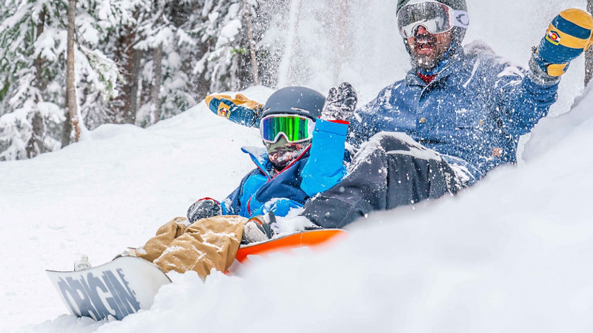 Father and son ride the fresh snow together in Keystone, CO.