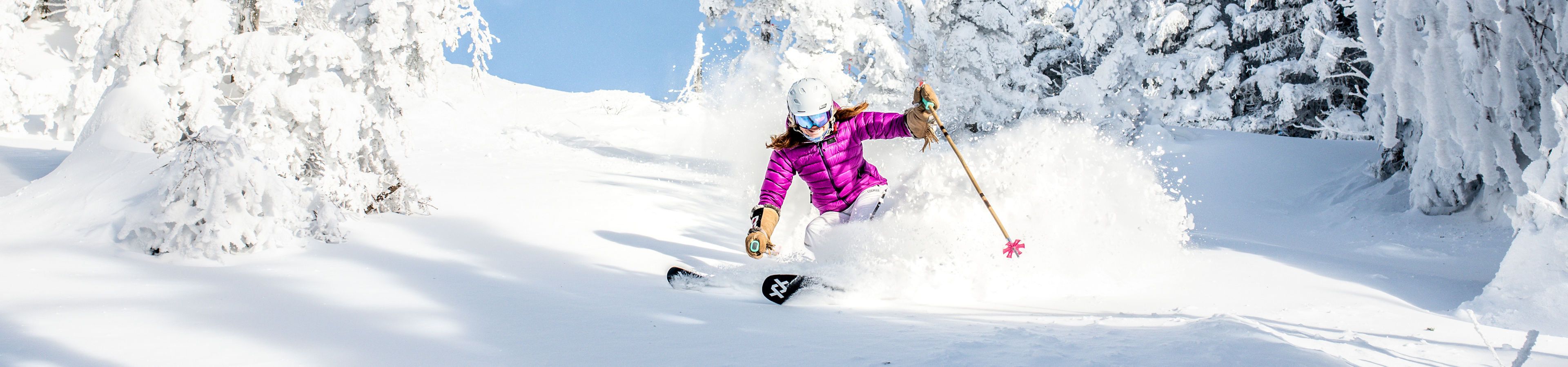 Women Skis Through Snow Covered Trees in Stowe Mountain Resort
