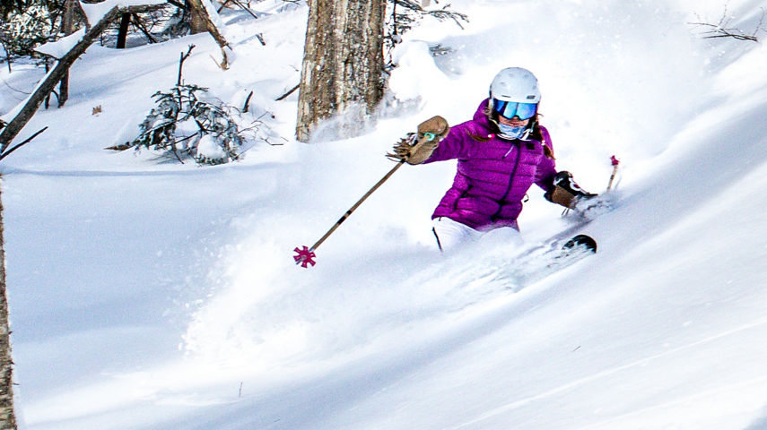 Women Skis Through Snow Covered Trees in Stowe Mountain Resort