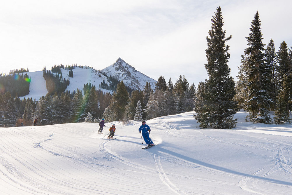Kids ski school group skiing with instructor at Crested Butte
