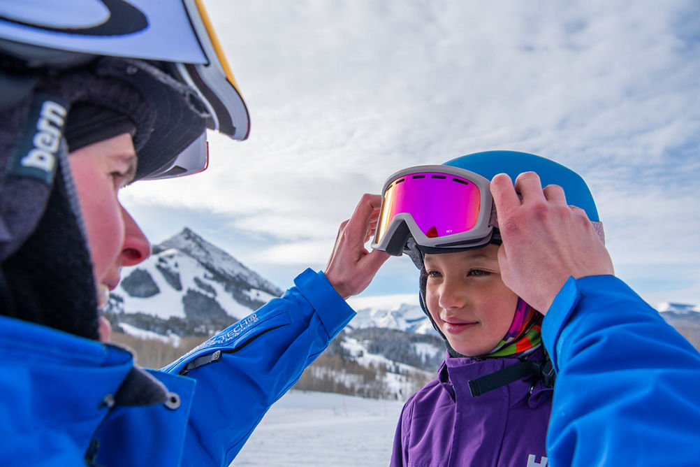 Instructor helping student with helmet at Crested Butte