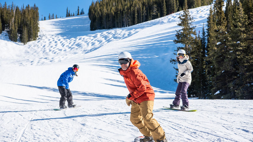 Adult Snowboard group rides down from Silver Queen Express at Crested Butte
