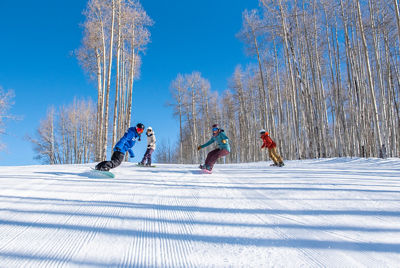Adult snowboard lesson riding down groomer at Crested Butte