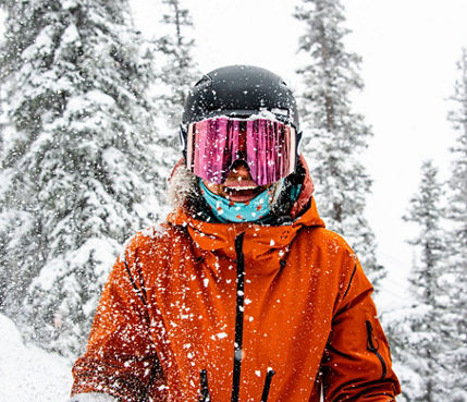 Female skier smiling at camera in fresh snow at Crested Butte
