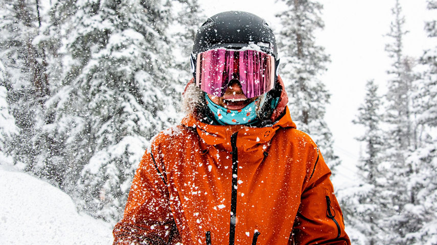 Female skier smiling at camera in fresh snow at Crested Butte