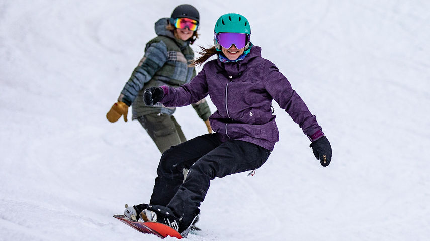 Two Women Smile and Snowboard at Hunter Mountain