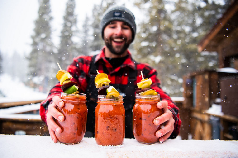 Bartender at Uley's Cabin placing Bloody Marys on bar at Crested Butte