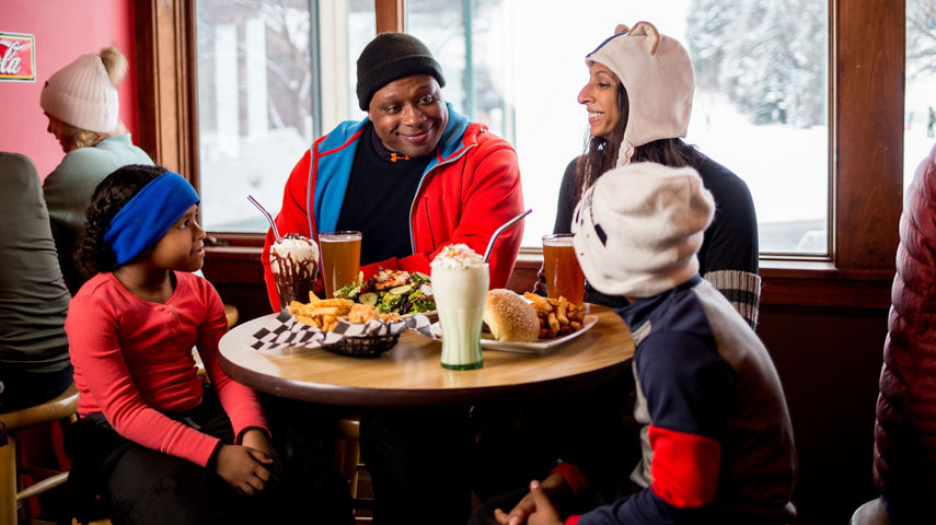 Family Smiles With Milkshakes and Food at 1900' Burger