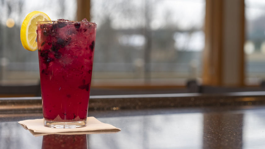 Mixed drink with berries and lemon at Solstice Bar