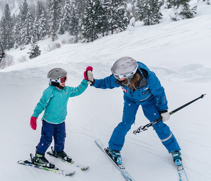 Young children skiing with an instructor