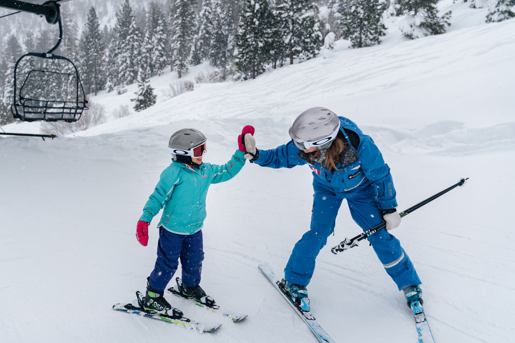 Young children skiing with an instructor