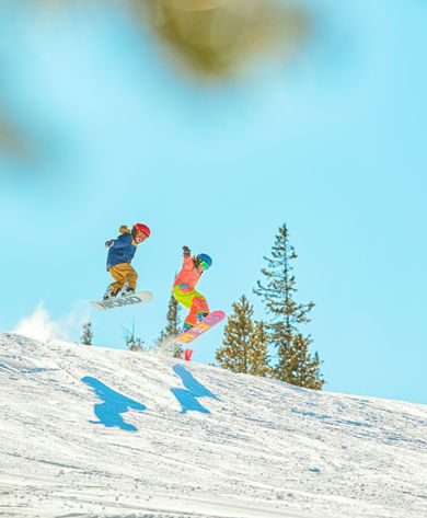 Two snowboarders catching air in terrain park at Keystone Resort