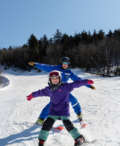 Child Skiing with Instructor with Arms Out at Mount Sunapee