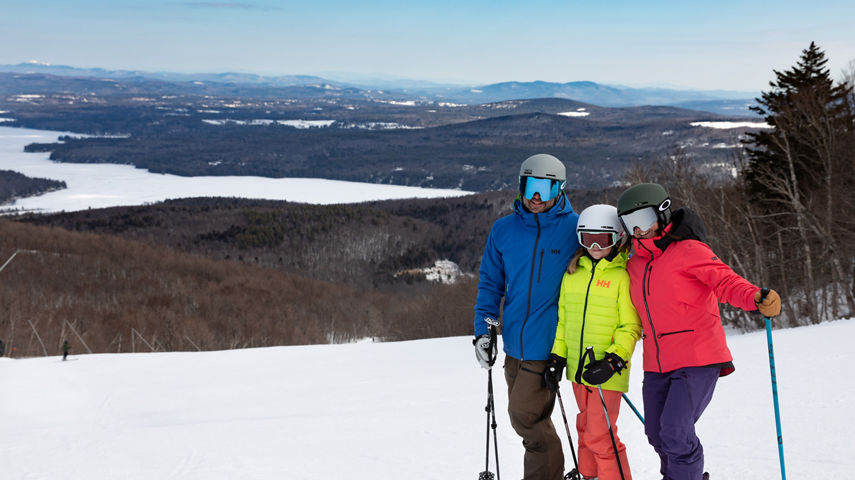 Two Parents and One Child Posing with View of Lake  at Mount Sunapee