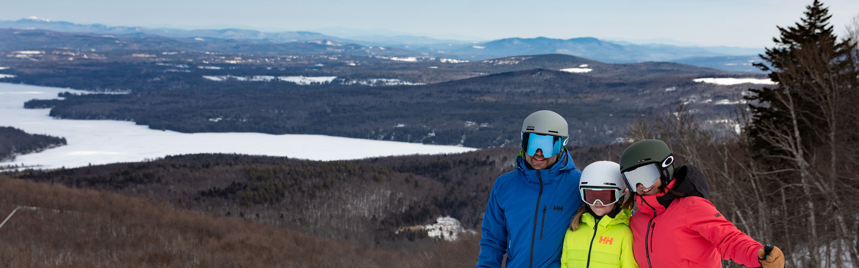 Two Parents and One Child Posing with View of Lake  at Mount Sunapee