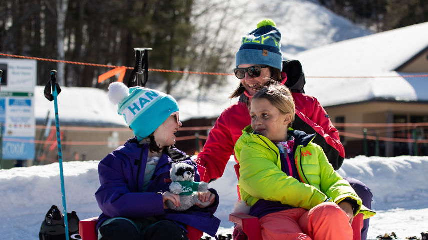 Two Children Sitting with Mom  at Mount Sunapee