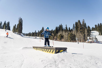 Child Rides Over a Terrain Park Box on a Spring Day at Northstar California