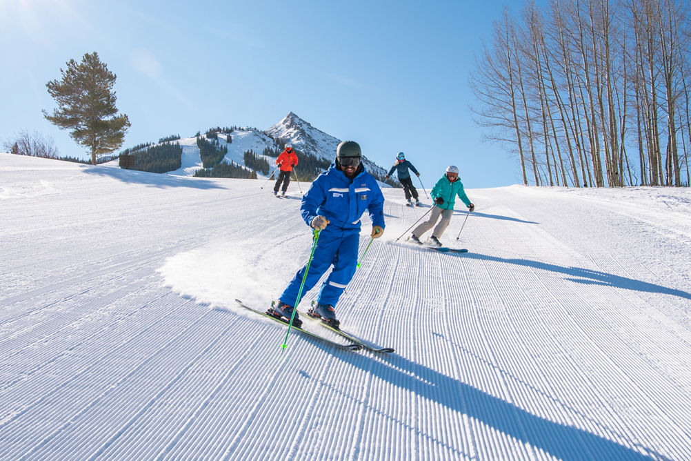 Adult ski group with peak in background at Crested Butte