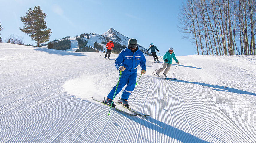 Adult ski group with peak in background at Crested Butte
