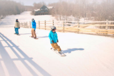 Parents and Child Snowboarding on Beginner Terrain at Okemo