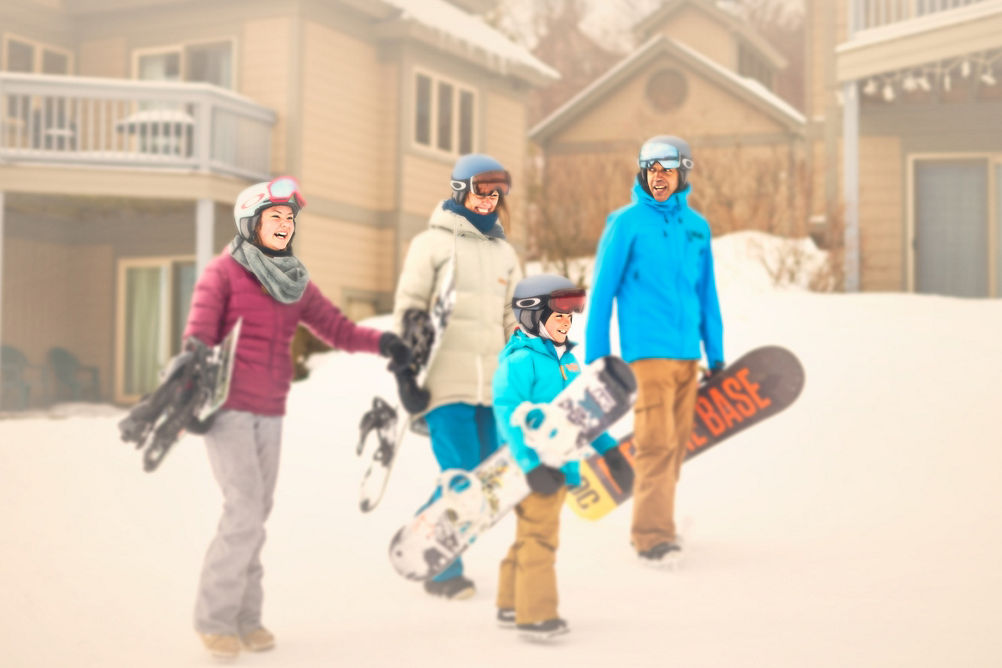 Family Walking From Condo to Trails with Snowboards