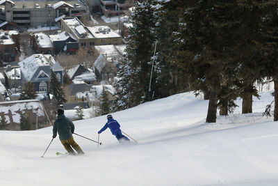 Man skiing with an instructor into town at Park City