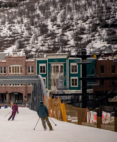 Friends skiing over town bridge at Park City