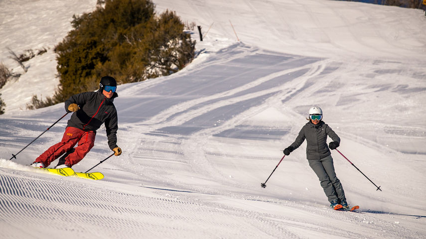 Friends skiing down a groomer at Park City