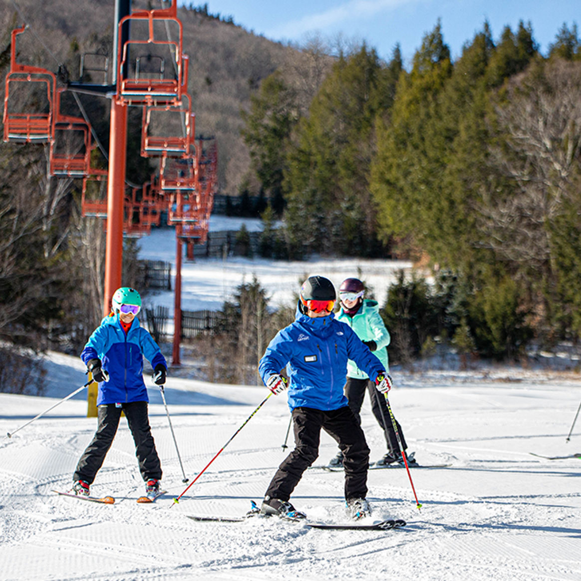 Beginner adults ski down slope