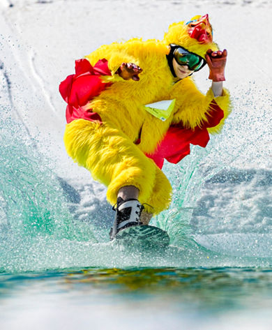 A guest in costume attempts pond skimming during Spring Fling at Wilmot