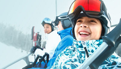 Family Riding Chairlift and Smiling at Okemo