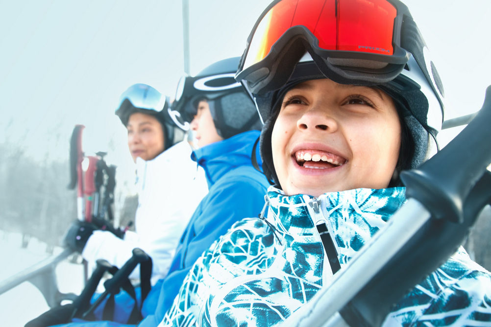 Family Riding Chairlift and Smiling at Okemo