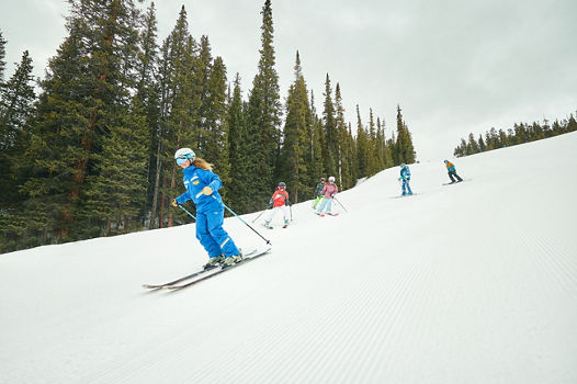 Youth ski group skiing with instructor at Keystone Resort