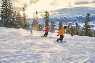 Friend group riding downhill during sunset at Keystone Resort