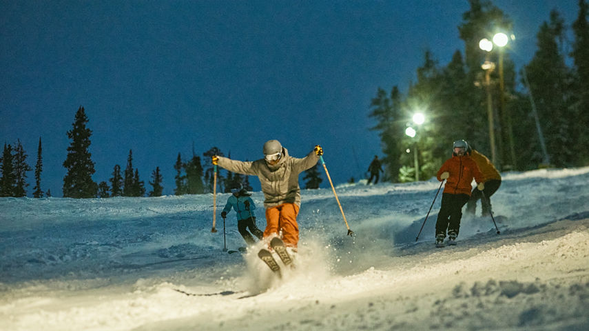 Group riding in fresh snow while night skiing at Keystone Resort