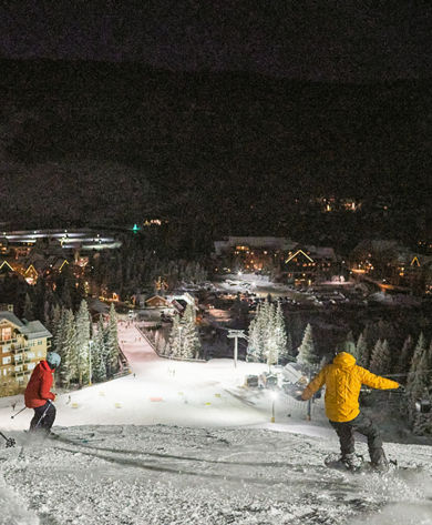 Group riding above the base area at Keystone Resort while night skiing