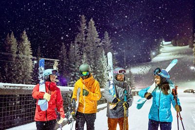 Friend group walking under the lights night skiing at Keystone Resort