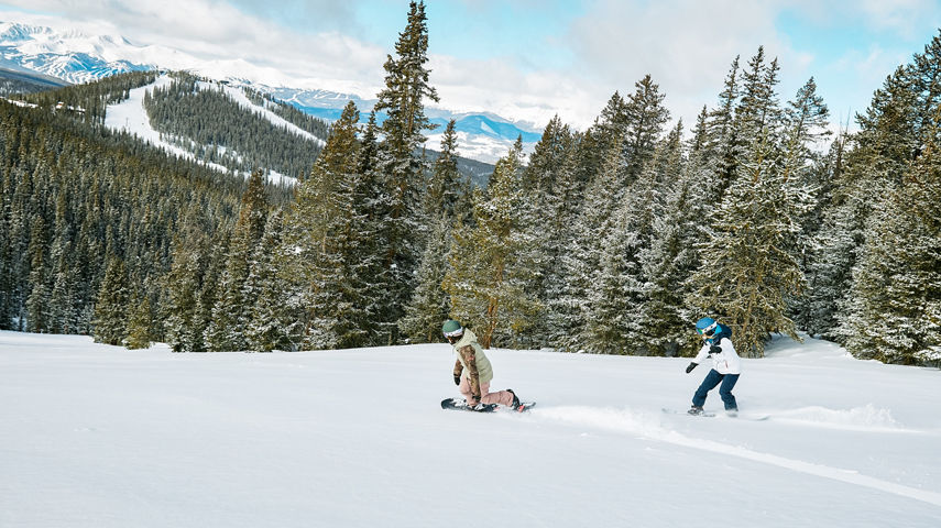 Snowboarders riding fresh snow after cat ride at Keystone Resort