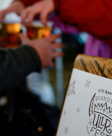 Bartender Hands Beer to Guest at Ullr Fest Event at Roundtop