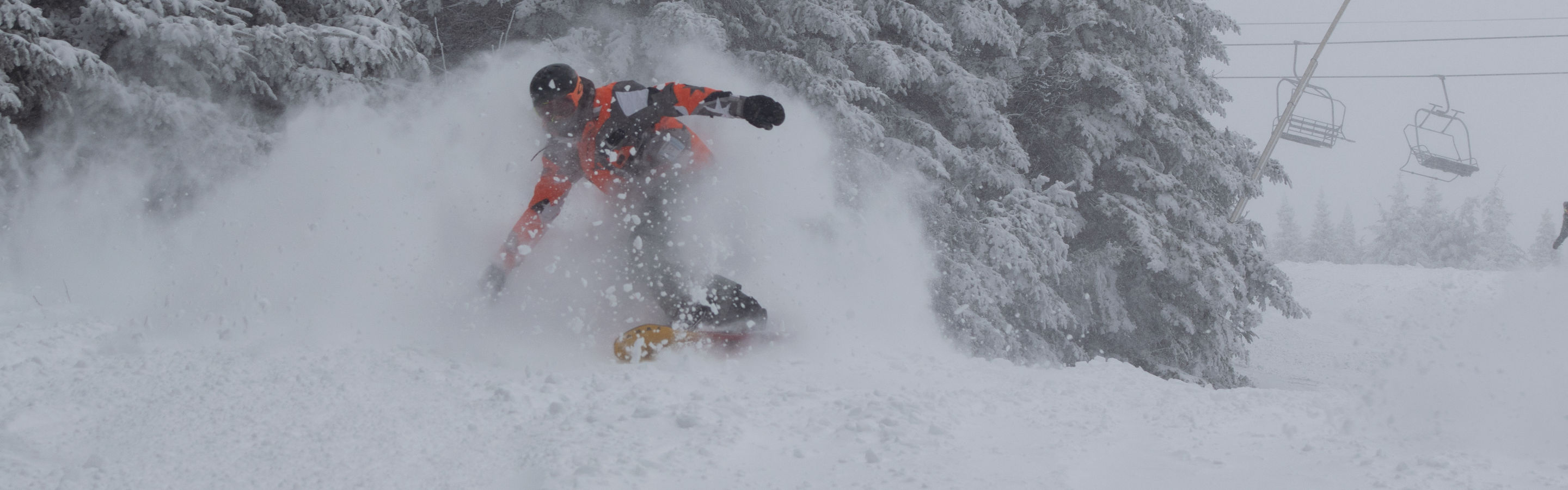 Snowboarder Rides Out of Trees on Snowy Day atMount Snow