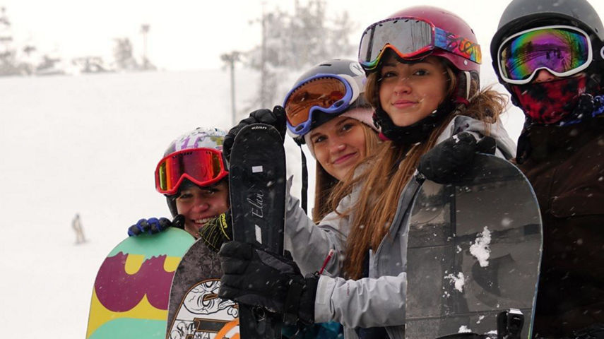 Group of Skiers and Riders Pose on Ski Run at Snow Creek