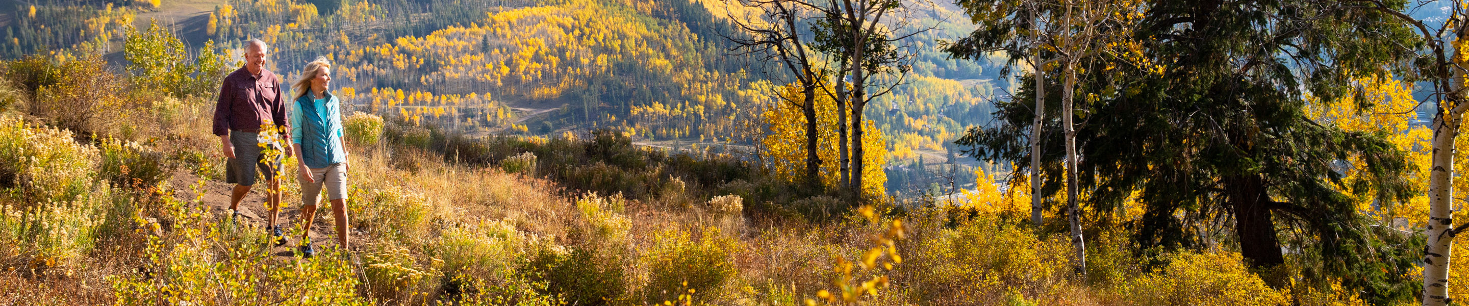 A couple enjoys a fall hike through Vail, Colorado