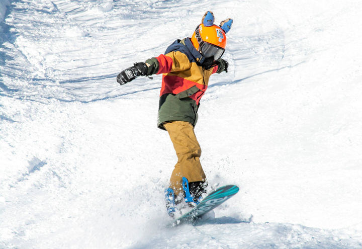 A young snowboarder having fun at Okemo